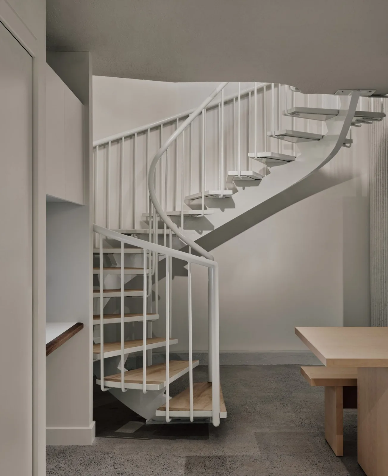 A spiral staircase leads down to a staff area in a basement